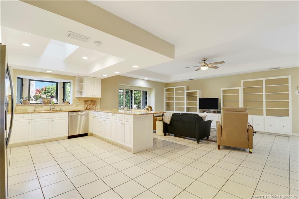 5701 Southeast Winged Foot Drive Stuart, FL 34997 - Photo 15 of 47 a kitchen with a chair and white cabinets
