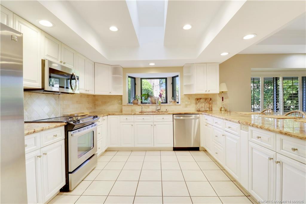 5701 Southeast Winged Foot Drive Stuart, FL 34997 - Photo 16 of 47 a kitchen with a stove sink and cabinets