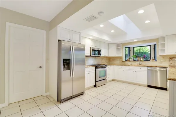a kitchen with a refrigerator and white cabinets