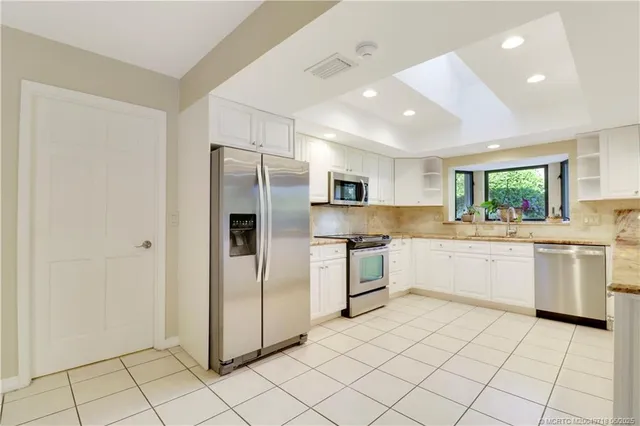 a living room with furniture a flat screen tv and a chandelier