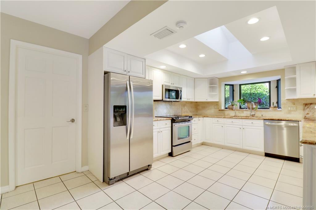 5701 Southeast Winged Foot Drive Stuart, FL 34997 - Photo 17 of 47 a kitchen with a refrigerator and white cabinets