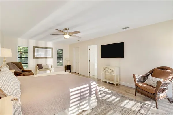 a living room with furniture a flat screen tv and a chandelier