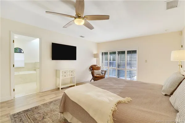 a bedroom with a bed and a flat tv screen on dresser