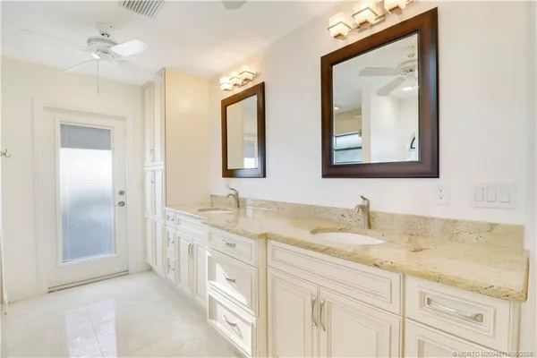 a bathroom with a granite countertop double vanity sink mirror and