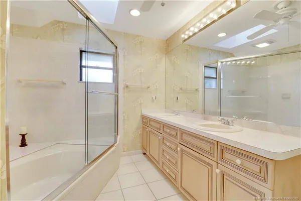 a spacious bathroom with a shower sink and mirror
