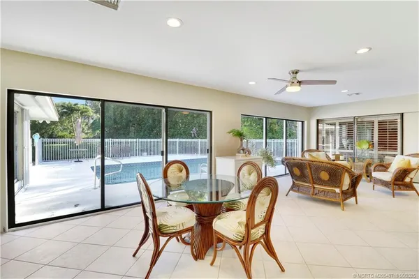 a dining room with furniture and a floor to ceiling window