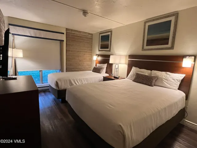 a bedroom with bed and wooden floor