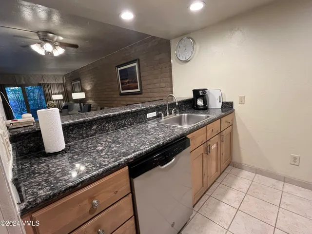 a kitchen with granite countertop a sink a counter top space and cabinets