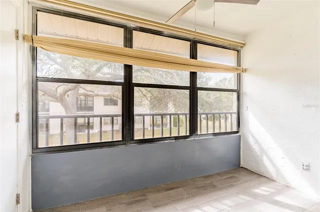 an empty room with windows and fan