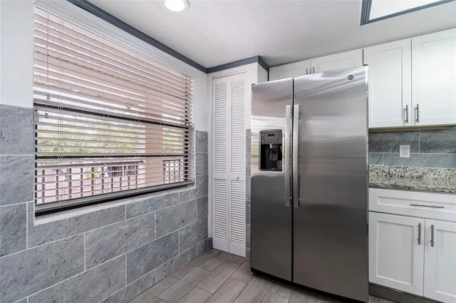 a kitchen with stainless steel appliances granite countertop a refrigerator and a sink