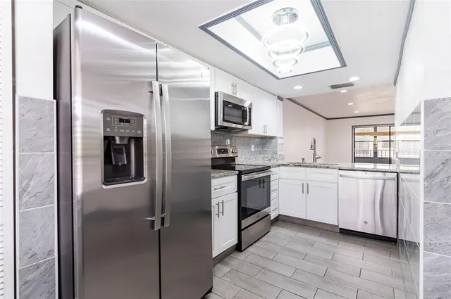 a kitchen with stainless steel appliances granite countertop a sink and a stove