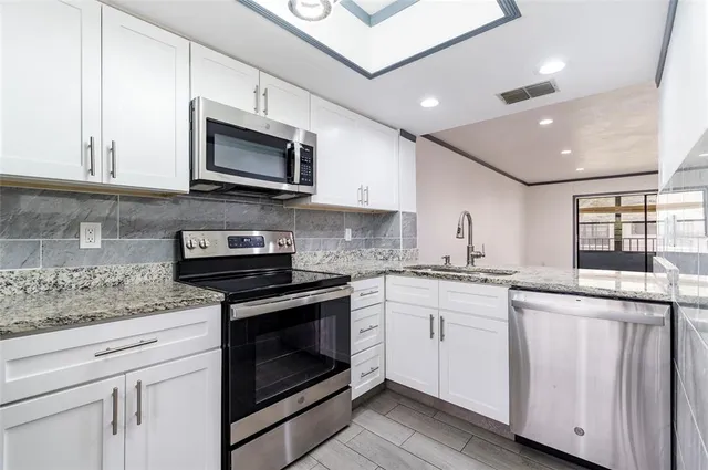 a kitchen with stainless steel appliances granite countertop a stove and a microwave