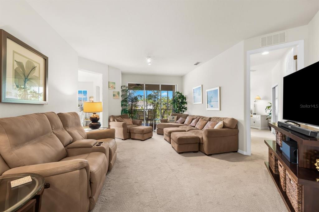 4500 Streamside Court, Unit 1408 Sarasota, FL 34238 - Photo 18 of 73 a living room with furniture and a flat screen tv