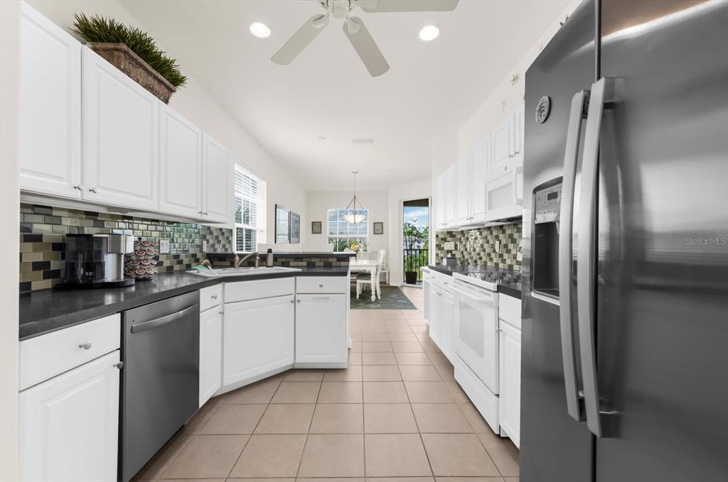 4500 Streamside Court, Unit 1408 Sarasota, FL 34238 - Photo 31 of 73 a kitchen with stainless steel appliances granite countertop a refrigerator and a stove top oven