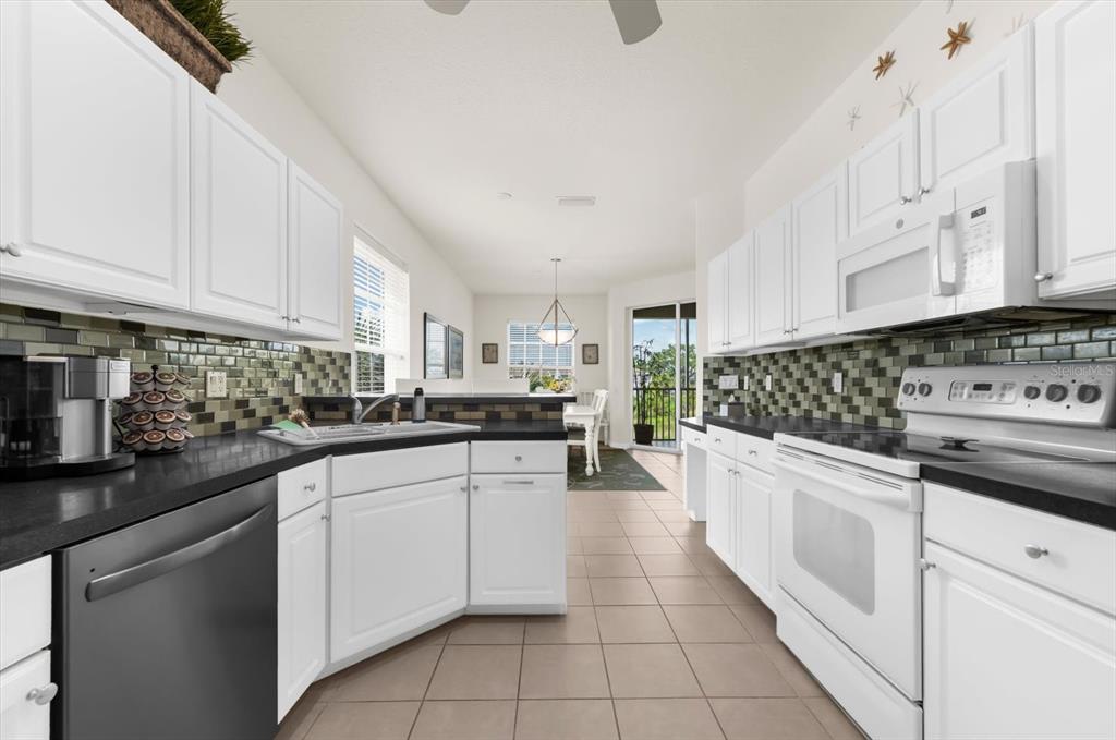 4500 Streamside Court, Unit 1408 Sarasota, FL 34238 - Photo 33 of 73 a kitchen with white cabinets appliances and a sink