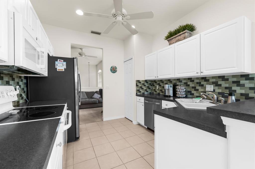 4500 Streamside Court, Unit 1408 Sarasota, FL 34238 - Photo 34 of 73 a kitchen with stainless steel appliances granite countertop a sink stove and refrigerator