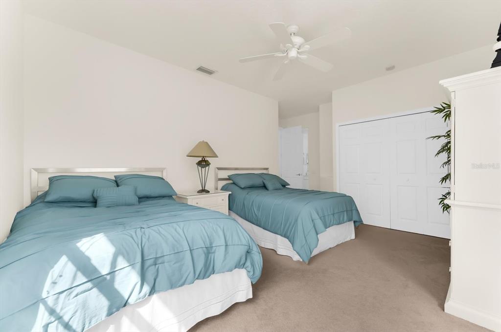 4500 Streamside Court, Unit 1408 Sarasota, FL 34238 - Photo 49 of 73 a bedroom with two beds and a chandelier