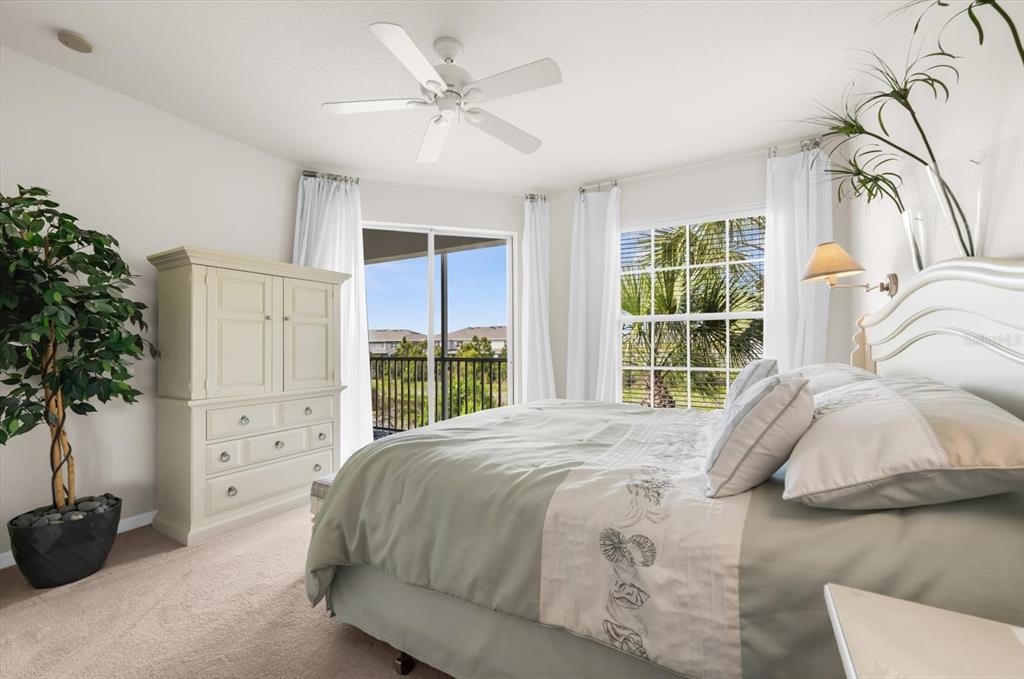 4500 Streamside Court, Unit 1408 Sarasota, FL 34238 - Photo 59 of 73 a bed sitting in a bedroom next to a window with potted plants
