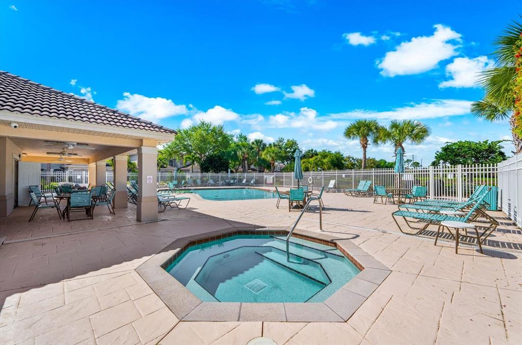 4500 Streamside Court, Unit 1408 Sarasota, FL 34238 - Photo 70 of 73 a view of a patio with dining table and chairs with a small yard