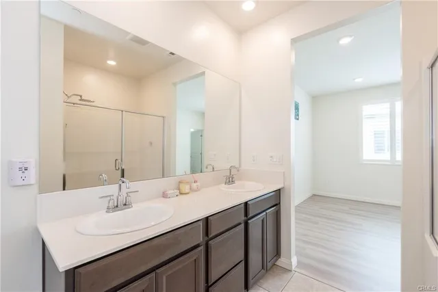 a bathroom with double sink and a mirror