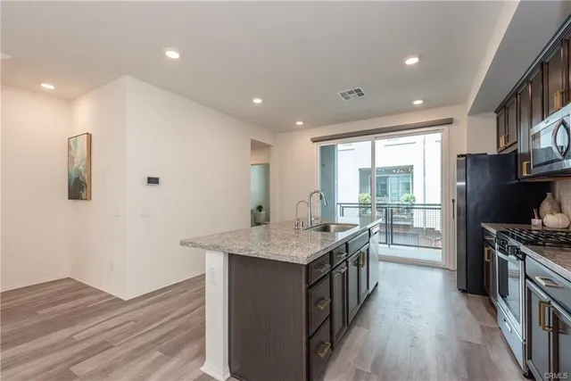 a kitchen with stainless steel appliances granite countertop a stove and a wooden floors