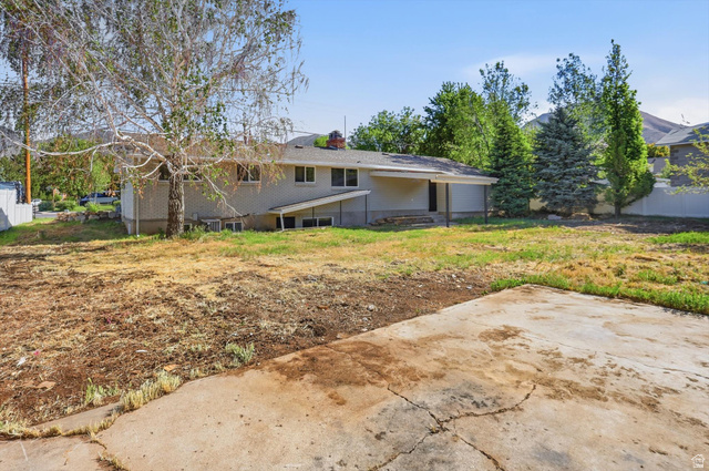 810 East Maple Street Mapleton, UT 84664 - Photo 30 of 49 Expansive rear yard featuring mature trees, a concrete patio, and a covered back porch