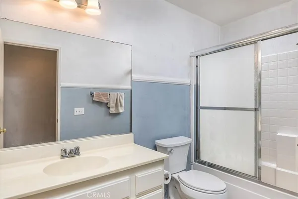 a bathroom with a sink a toilet a shower and a mirror