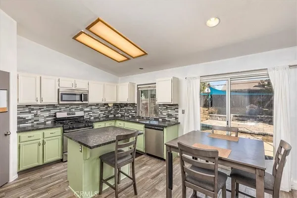 a kitchen with a stove a sink and chairs