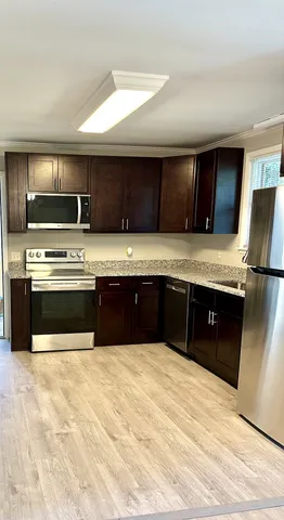 a kitchen with stainless steel appliances granite countertop a stove a sink and a refrigerator