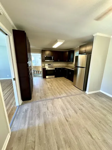 a view of kitchen with sink and refrigerator