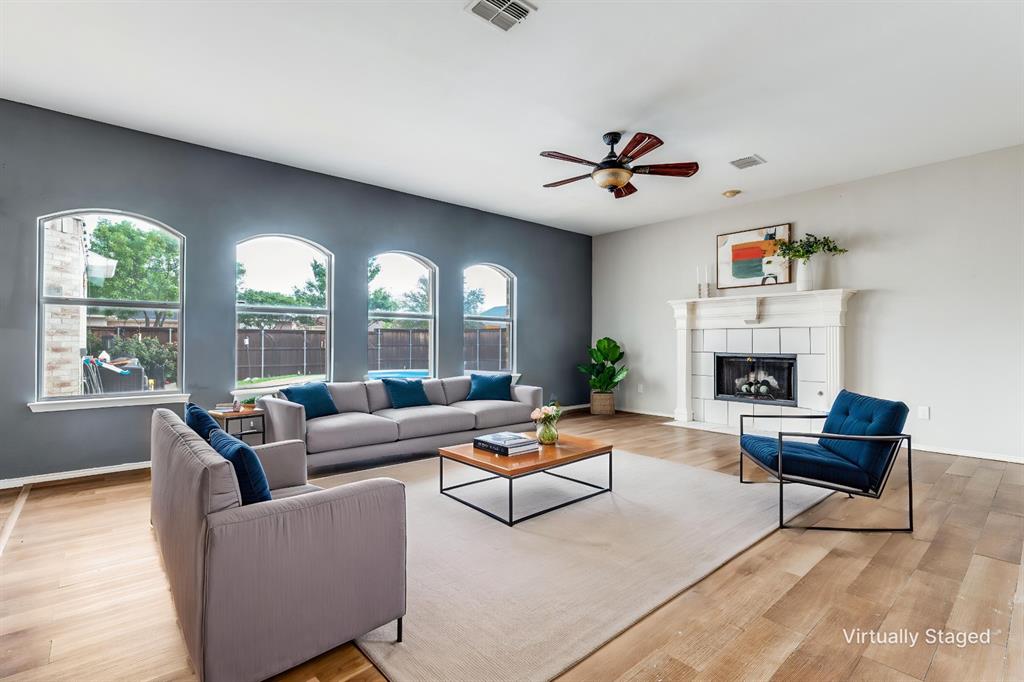 1445 Berkley Road Allen, TX 75002 - Photo 6 of 30 The family room is warmed by a cozy fireplace with gas logs and features a wall of gracefully arched windows overlooking the patio and beautiful pool.