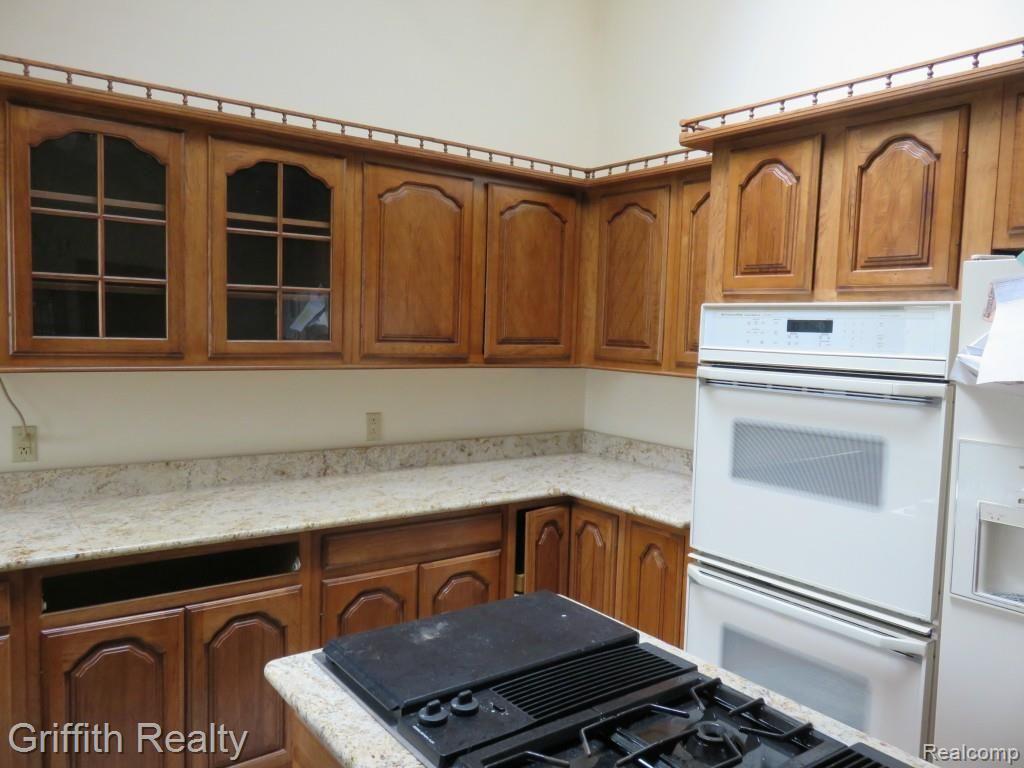 20563 Wasson Road Pinckney, MI 48169 - Photo 17 of 44 Hickory/granite kitchen w/ good view of cook island and double ovens in pic...the drawer that is missing is onsite