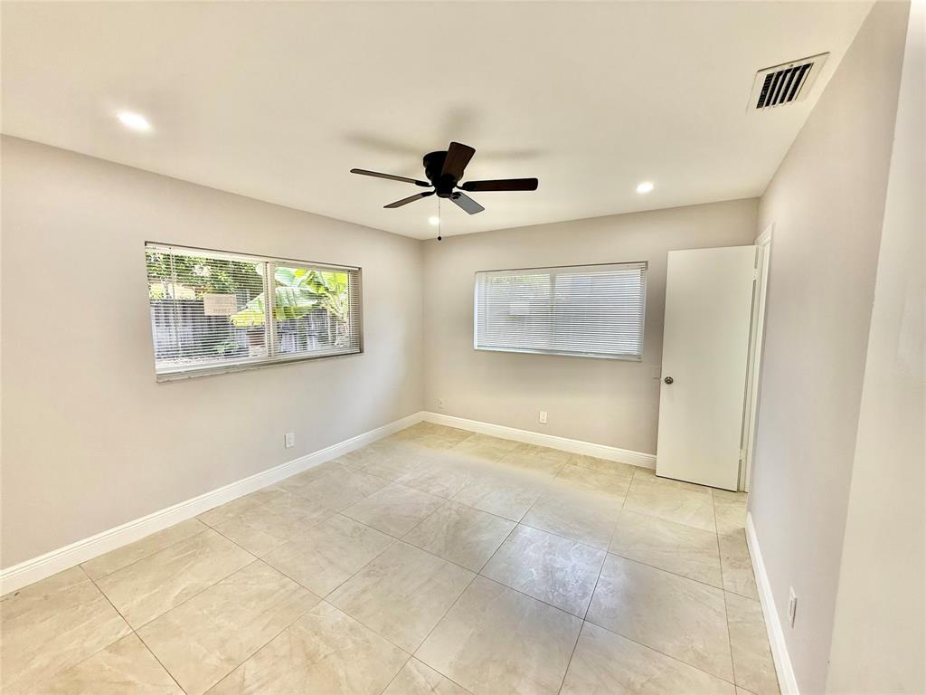 2210 Northeast 54th Street, Unit W Fort Lauderdale, FL 33308 - Photo 11 of 21 an empty room with windows and ceiling fan