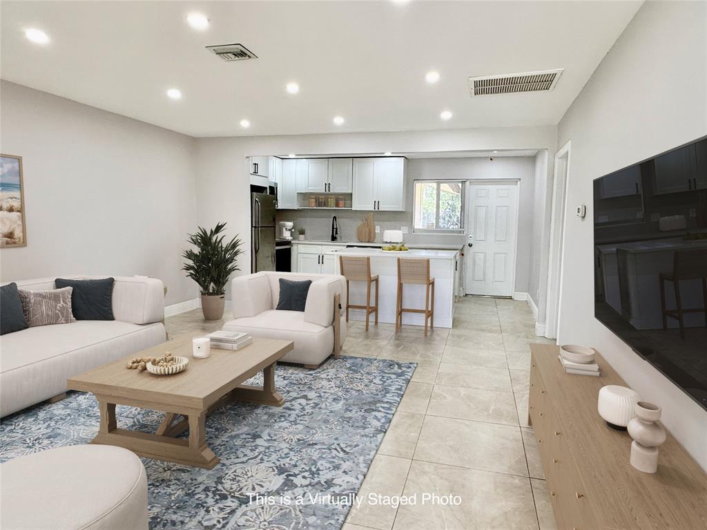 2210 Northeast 54th Street, Unit W Fort Lauderdale, FL 33308 - Photo 3 of 21 a living room with furniture a rug and a flat screen tv