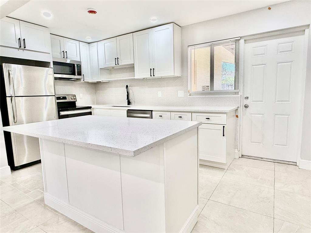 2210 Northeast 54th Street, Unit W Fort Lauderdale, FL 33308 - Photo 5 of 21 a kitchen with cabinets and appliances