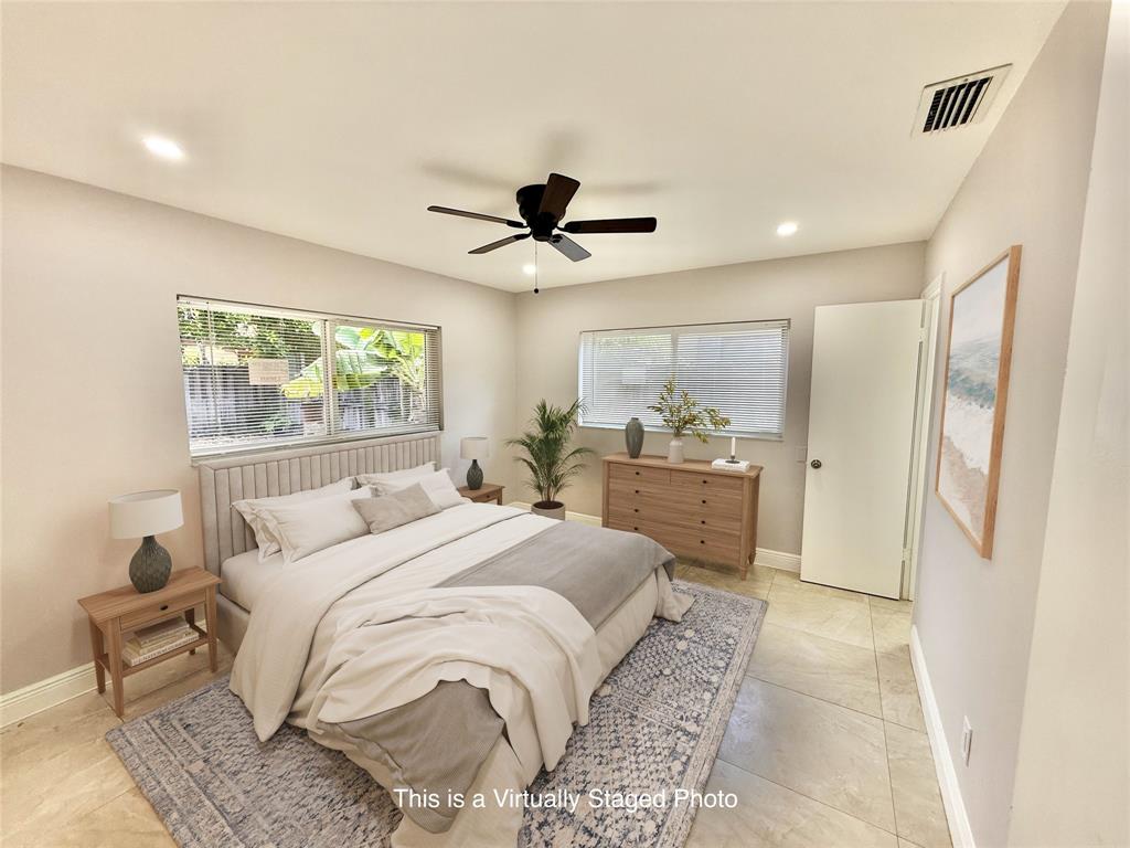 2210 Northeast 54th Street, Unit W Fort Lauderdale, FL 33308 - Photo 10 of 21 a bedroom with a large bed and a chandelier