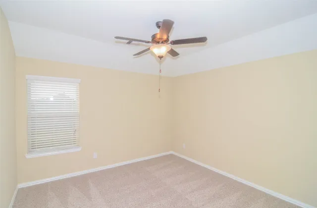 a view of a room with a window and a ceiling fan
