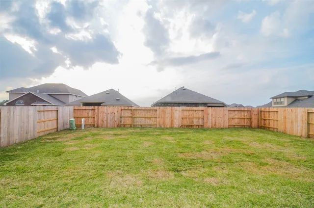 a view of a house with a yard and fence