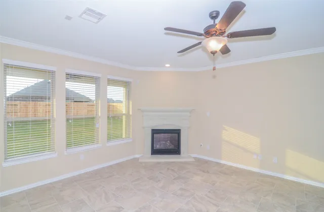 a view of an empty room with a fireplace and a window