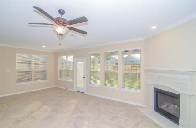 a view of an empty room with a window and a fireplace
