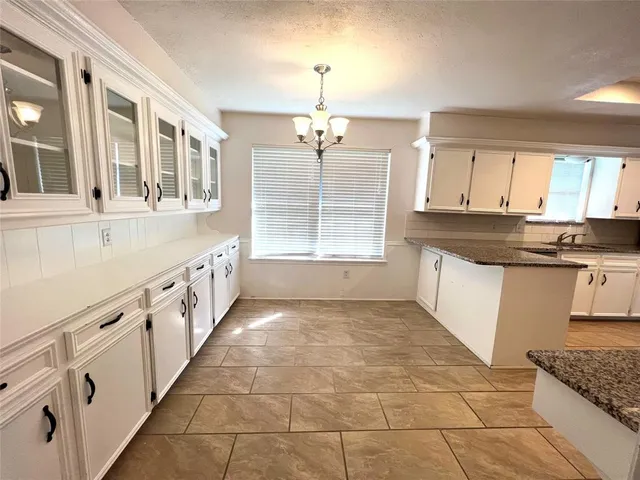 a view of a kitchen with granite countertop a sink and a stove top oven