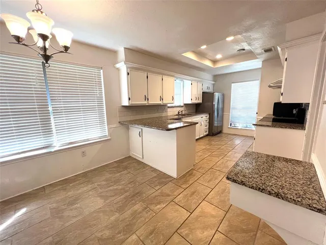 a kitchen with stainless steel appliances granite countertop a stove a sink and a microwave