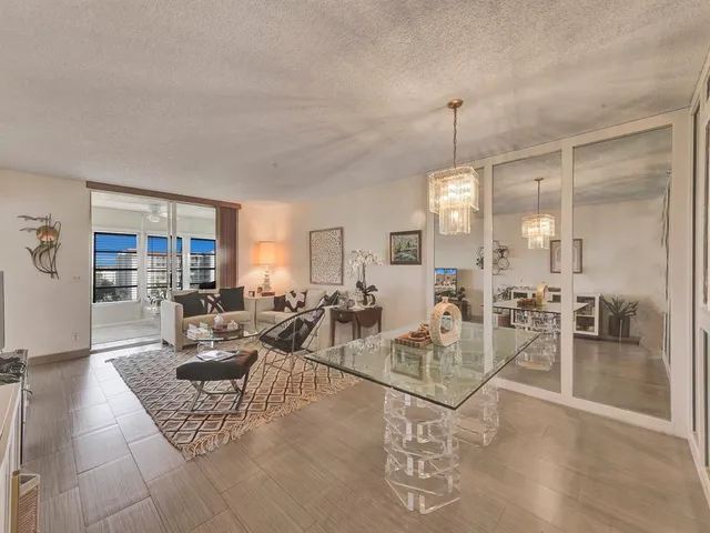 a living room with furniture a dining table and a chandelier