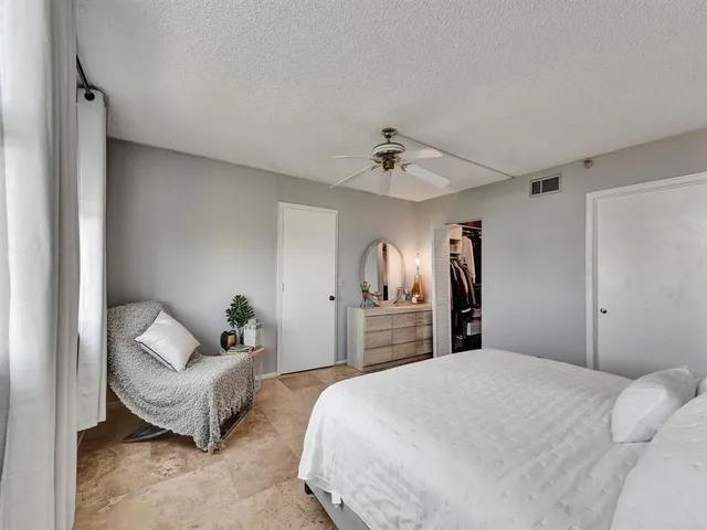 a spacious bedroom with a bed and lamp chandelier