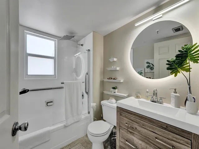 a bathroom with a sink mirror toilet and shower