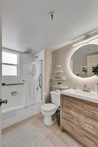 a bathroom with a granite countertop toilet a sink and a mirror