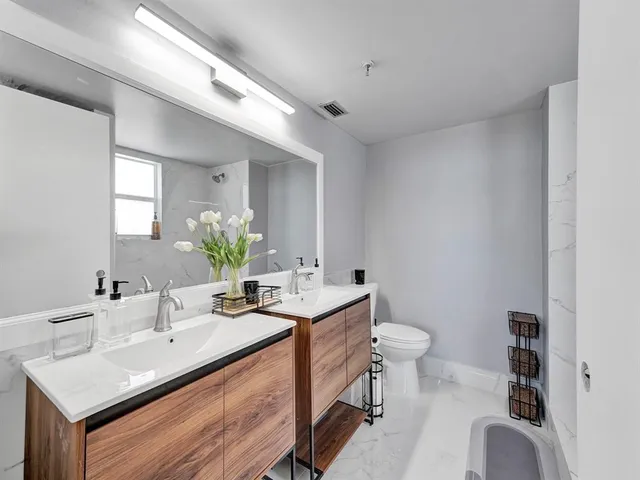 a bathroom with a sink toilet and a mirror