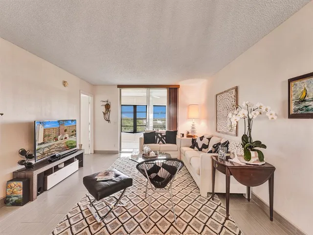 a living room with furniture a rug and a flat screen tv
