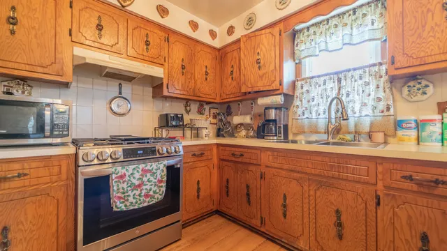 a kitchen with stainless steel appliances granite countertop a stove and cabinets