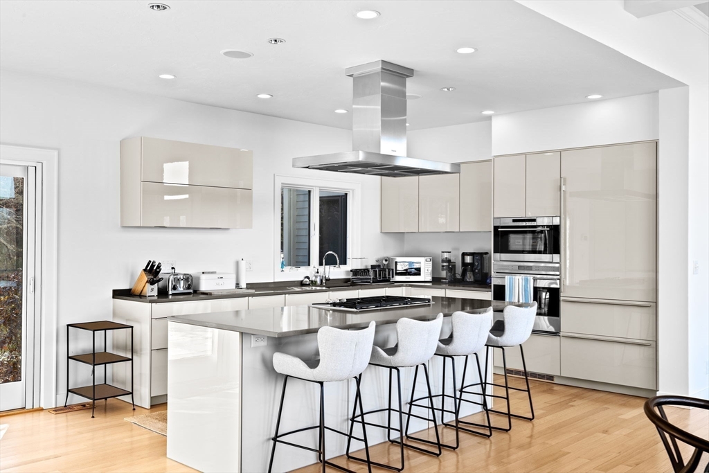 68 Nichols Road Cohasset, MA 02025 - Photo 11 of 41 a kitchen with stainless steel appliances kitchen island granite countertop a stove top oven a sink a dining table and chairs